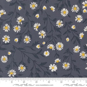 May include: Dark grey fabric featuring a floral pattern of white daisies with yellow centres and dark green stems and leaves. A ruler is along the bottom edge with the word "moda" printed on it.