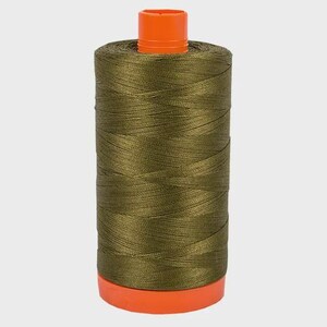 Pode incluir: Um carretel cilíndrico grande de linha de costura verde-oliva. O carretel apresenta uma tampa de plástico laranja brilhante no topo e uma base de plástico laranja correspondente na parte inferior. A linha é enrolada em um padrão cruzado.