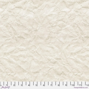 Peut inclure: Gros plan sur un tissu beige à texture de papier froissé. Le tissu comporte une échelle le long du bord inférieur, graduée en pouces. Les mots "Free Spirit" et "freespiritfabrics.com" sont visibles.