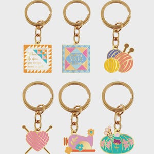 Può includere: Sei portachiavi color oro con vari ciondoli a tema quilting. I ciondoli includono un blocco di trapuntatura con testo, un ciondolo quadrato con testo, gomitoli di lana, un cuore con ferri da maglia, una macchina da cucire e una zucca turchese con accenti floreali.