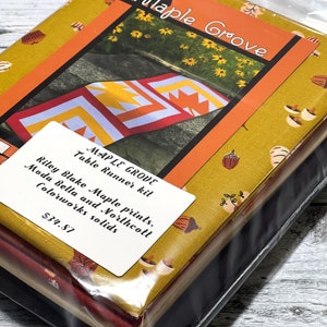 May include: A fabric kit for a table runner called "Maple Grove". The kit includes fabrics from Riley Blake, Moda Bella, and Northcott. The kit is $34.87.