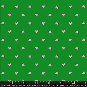 Puede incluir: Tela verde con un patrón repetido de pequeños corazones rosas. Los corazones están espaciados uniformemente sobre la superficie. En la parte inferior de la tela hay una regla y el texto "RUBY STAR SOCIETY".