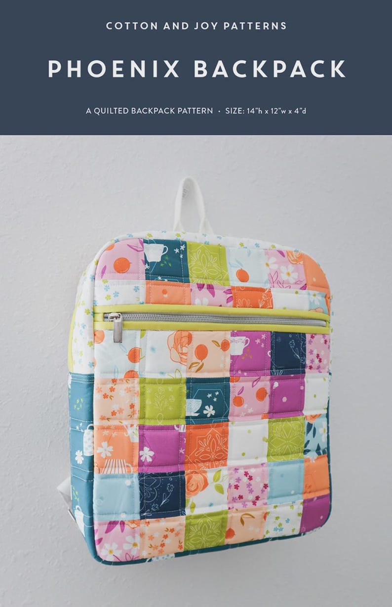 May include: A colorful, quilted Phoenix backpack with a patchwork design. The bag features a variety of floral and geometric patterns in shades of pink, orange, green, and blue. It has a zippered closure and measures 14" high x 12" wide x 4" deep.