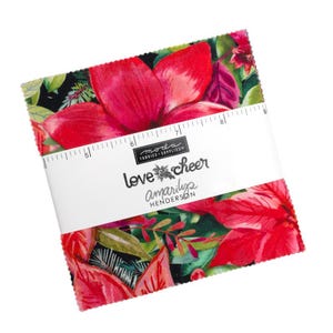 Könnte beinhalten: Ein Stapel Stoffquadrate mit einem lebendigen Blumendesign mit großen roten Blüten und grünen Blättern. Der Stoff ist mit einem weißen Band mit der Aufschrift "Love & Cheer Amarilys Henderson" und einem Lineal umwickelt.