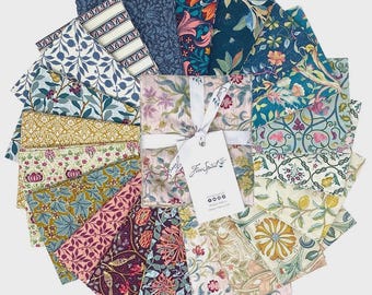 May include: A collection of patterned fabric squares in various colors and floral designs. The fabrics are arranged in a circular pattern, with a central bundle tied with a white ribbon and a tag that reads "Free Spirit".