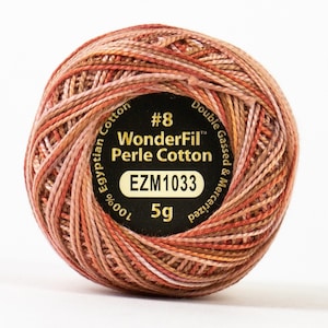 May include: A spool of #8 WonderFil Perle Cotton thread in a multi-colored blend of pink, orange, and brown. The spool is labeled "100% Egyptian Cotton, Double Gassed & Mercerized, EZM1033, 5g".