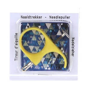May include: A yellow plastic needle puller tool with a circular finger grip and a metal tip, packaged in a clear plastic blister pack on a white card. The card features the text Naaldtrekker - Needlepuller, Tireur d'aiguille, and Nadelzieher.