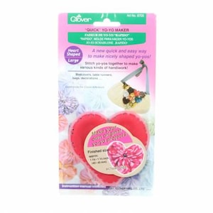 May include: A Clover brand heart-shaped yo-yo maker in a pink retail package. The packaging features text including "QUICK YO-YO MAKER" and "Heart Shaped Large." A circular label indicates a finished size of approximately 1 5/8 x 1 3/4 inches.