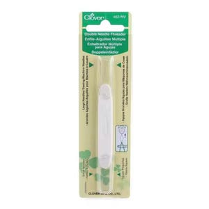 May include: A Clover brand double needle threader in its original retail packaging. The tool is white with a long, slender body and is designed for sewing machines. The packaging is light green and white with text including Double Needle Threader.