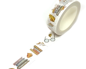 May include: A roll of white washi tape featuring a repeating watercolour pattern of stacked books, round spectacles, autumn leaves, and acorns. The text FOLK PAPER is printed in small, light grey letters along the length of the adhesive tape.