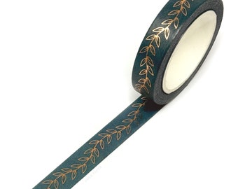 May include: A roll of teal washi tape with a gold leaf pattern. The tape is unspooled, revealing the leaf design along its length. The tape is on a white background. The brand name "FOLK PAPER" is printed on the tape.