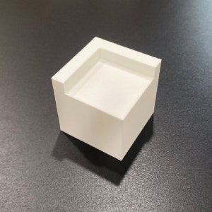 May include: A white ceramic square-shaped planter with a raised edge around the top.