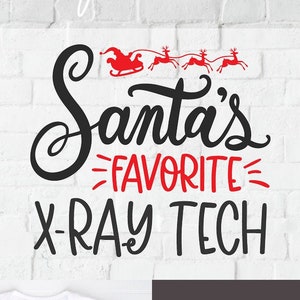 Op de afbeelding: Een wit T-shirt met een rood en zwart ontwerp met de tekst "Santa's favoriete röntgentechnicus". Het ontwerp bevat een rode slee met rendieren die door de lucht vliegen. Het T-shirt is op een witte bakstenen achtergrond met een rood-zwart geruit overhemd en een blauwe spijkerbroek.