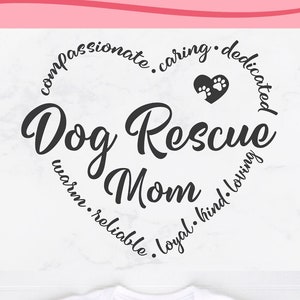 May include: A white t-shirt with a black circle design that says "Dog Rescue Mom" with paw prints in a heart shape. The circle is surrounded by the words "compassionate, caring, dedicated, warm, reliable, loyal, kind, loving".