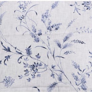 May include: A white fabric with a blue floral pattern. The pattern features delicate branches with small blue flowers and leaves.
