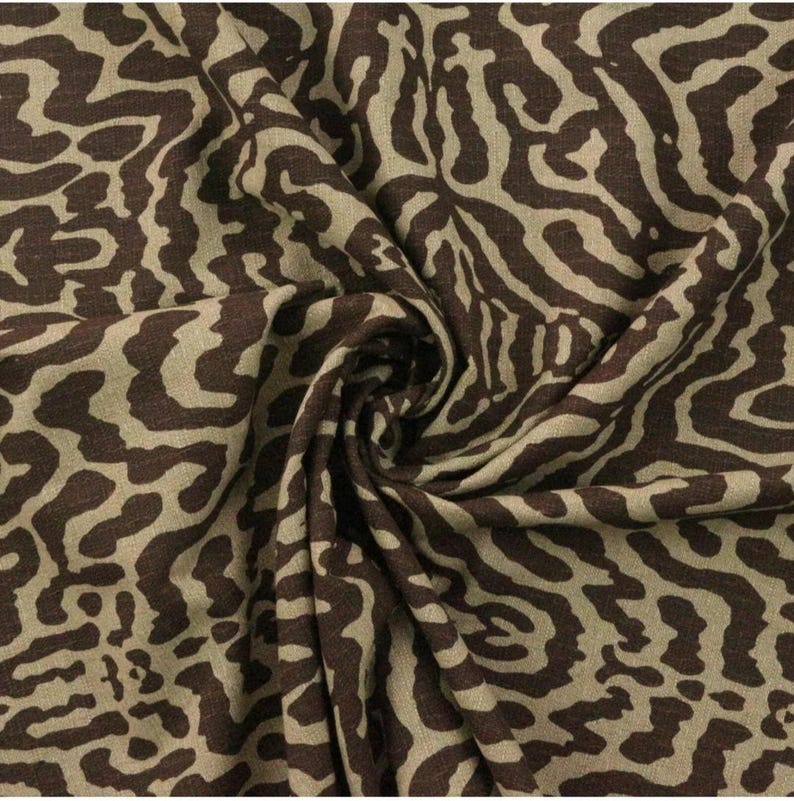 May include: Brown and beige fabric with a swirling, abstract animal print pattern.