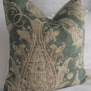 May include: A green and brown patterned throw pillow with a paisley design.
