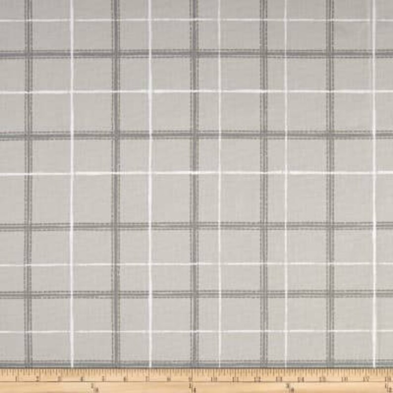 May include: A close-up of a gray and white plaid fabric with a subtle texture. The fabric has a woven appearance and is suitable for various sewing and crafting projects.