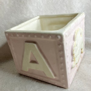 Roze pastelkleurige plantenbak met alfabetblokken