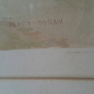 Puede incluir: Un primer plano de una obra de arte enmarcada con la firma del artista "Percy Moran" en tinta roja. La obra de arte est&aacute; sobre un fondo blanco con un passe-partout marr&oacute;n claro.