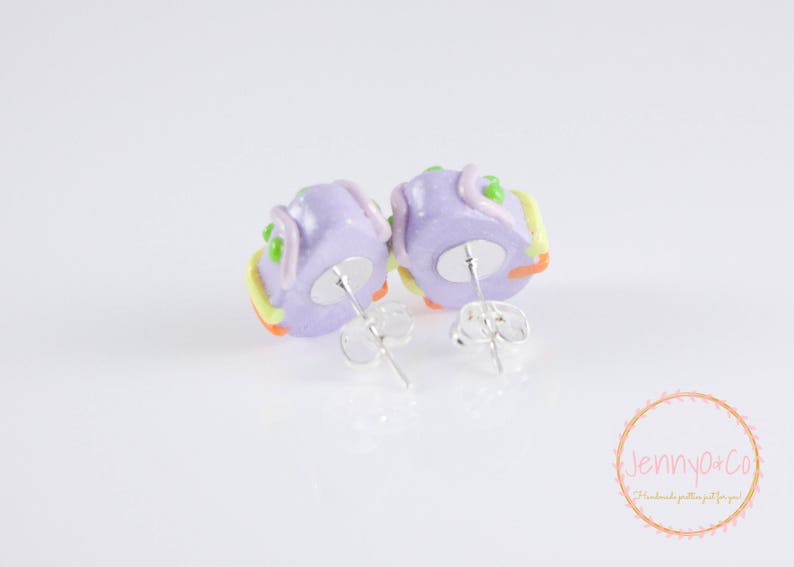 K&ouml;nnte beinhalten: Ein Paar violette und gelbe Polymer Clay Ohrringe in Form eines Kuchens mit Zuckerguss und Streuseln. Die Ohrringe haben silberne Ohrstecker.