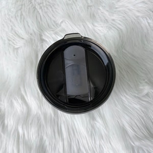 May include: Black travel mug with a black lid and a slider to open and close the lid.