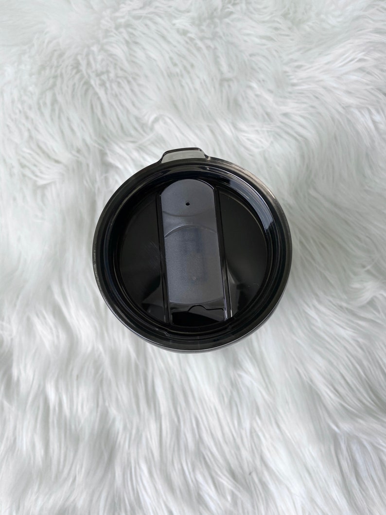 May include: Black travel mug with a black lid and a slider to open and close the lid.
