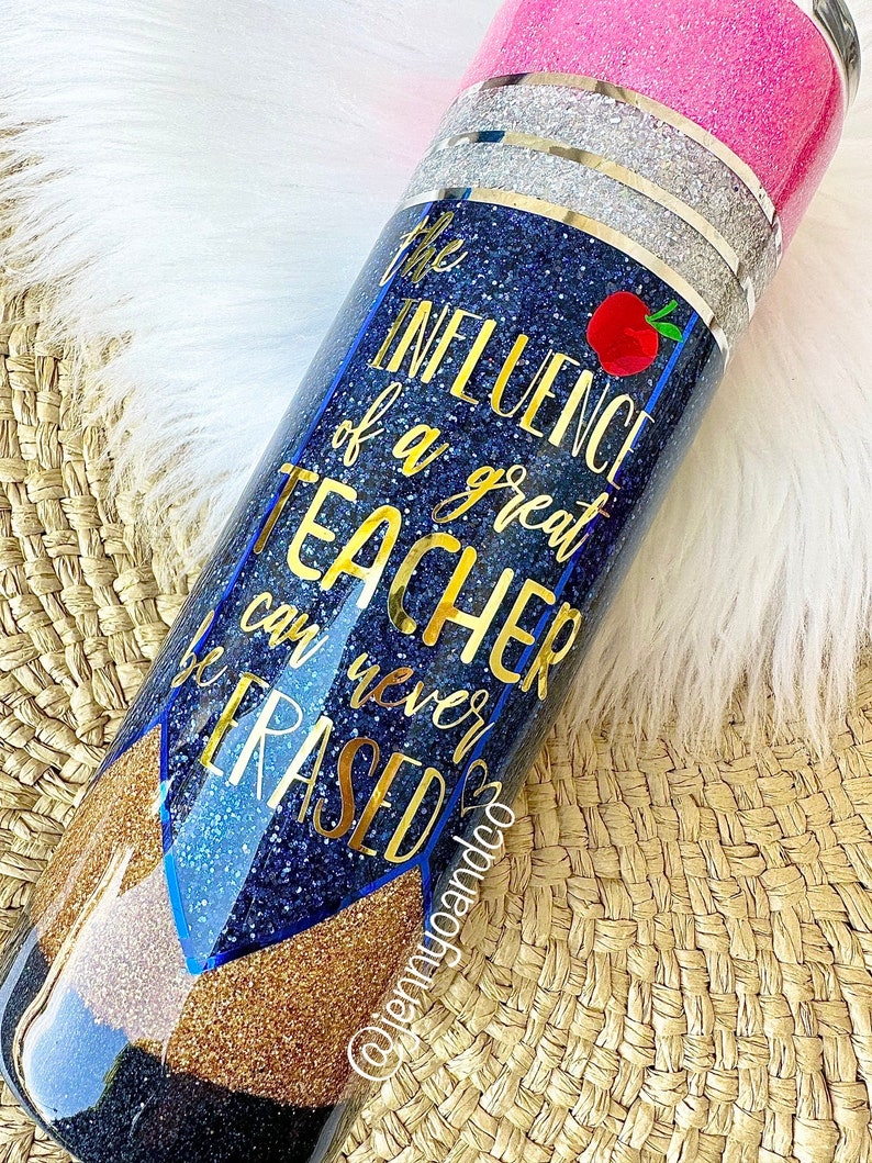 Puede incluir: Un vaso de glitter azul y dorado con el texto "La influencia de un gran maestro nunca se puede borrar".