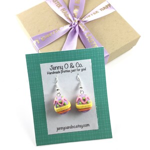 K&ouml;nnte beinhalten: Ein Paar silberne Ohrh&auml;nger mit pastellrosa, gelben und gr&uuml;nen Osterei-Anh&auml;ngern. Die Ohrringe werden auf einer gr&uuml;nen Karte mit dem Text "Jenny O & Co. Handmade pretties just for you! jennyoandco.etsy.com" pr&auml;sentiert.