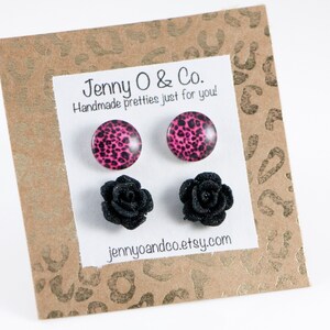 May include: A set of four stud earrings. Two earrings feature a pink and black leopard print design. The other two earrings feature a black rose design. The earrings are displayed on a brown card with the text "Jenny O & Co. Handmade pretties just for you! jennyandco.etsy.com"