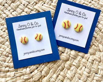 Peut inclure: Une paire de boucles d'oreilles en forme de balle de softball sur des cartes bleues avec le texte "Jenny O & Co. Handmade pretties just for you! jennyoandco.etsy.com"