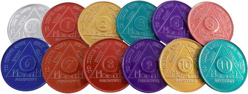 May include: Twelve round, silver, gold, red, purple, and teal colored metal tokens with a triangle design. Each token has a number from 1 to 12 and the words "To thine own self be true" and "Month of Recovery".