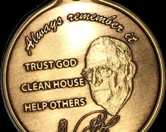 Peut inclure: Un porte-clés rond en métal doré avec un portrait d'un homme et le texte "Always remember to TRUST GOD CLEAN HOUSE HELP OTHERS" et une signature qui lit "L.B.J."