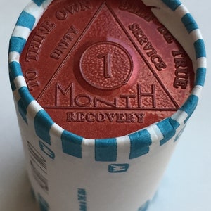 May include: A red, round, metal token with a triangle design and the words "To Thine Own Self Be True", "Unity", "Service", "One Month", and "Recovery".