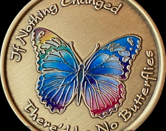 May include: A gold-colored round coin with a colorful butterfly in the center. The coin has the text "If Nothing Changed There'd Be No Butterflies" around the edge.