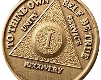 May include: Gold-toned metal coin with a triangle design featuring the words "To Thine Own Self Be True" and "Unity, Service, Recovery". The centre of the coin has the number "1" in a circle.