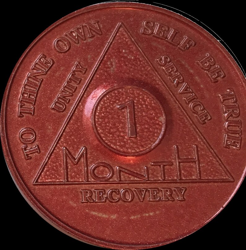 May include: A red metal coin with a triangle design and the words "To thine own self be true" and "Unity, Service" inscribed around the triangle. The center of the coin has a circle with the number "1" and the words "Month Recovery".