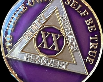 May include: Purple and gold coin with a triangle design. The triangle has the words "To thine own self be true" around the outside and "Unity, Service, Recovery" around the inside. The number "XX" is in the center of the triangle.