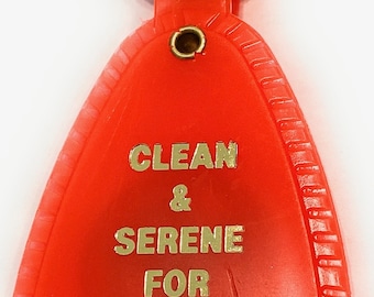 May include: A bright orange plastic keychain with a gold inscription that reads "Clean & Serene for Thirty Days".