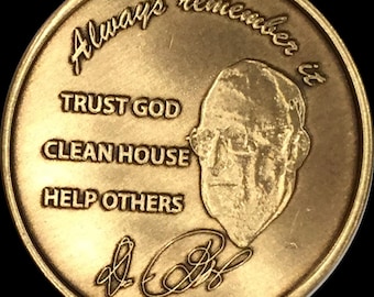 May include: A gold-coloured coin featuring a portrait of a man wearing glasses with the text "Always remember it" above the portrait. Below the portrait is the text "Trust God", "Clean House", and "Help Others". The coin also has a signature at the bottom.
