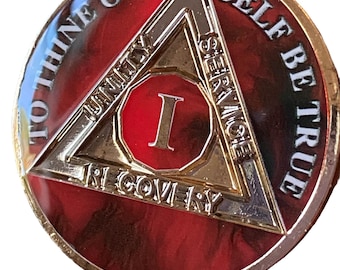 May include: A red, gold and white sobriety coin with the inscription "To thine own self be true" and a triangle with the words "Unity, Service, Recovery".