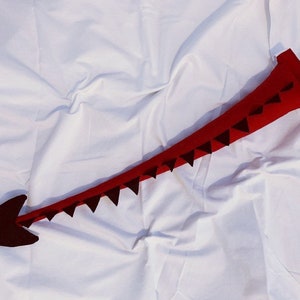 Red tail with black small black spikes and spade end. Dragon.