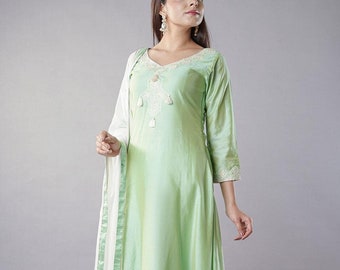 May include: A light green ombre kurta with white embroidery and a white dupatta with green trim. The kurta has a V-neckline and three-quarter sleeves. The dupatta is sheer and has a tassel at the end.