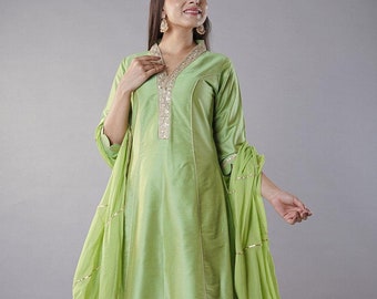 May include: A light green long-sleeved kurta with gold embroidery and a matching dupatta. The kurta has a V-neckline and a straight cut. The dupatta is sheer and has a gold border. The model is wearing matching green trousers.