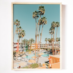 May include: A colorful mid-century modern hotel with a swimming pool surrounded by palm trees and lounge chairs. The hotel has a retro vibe with bright colors and a playful design.