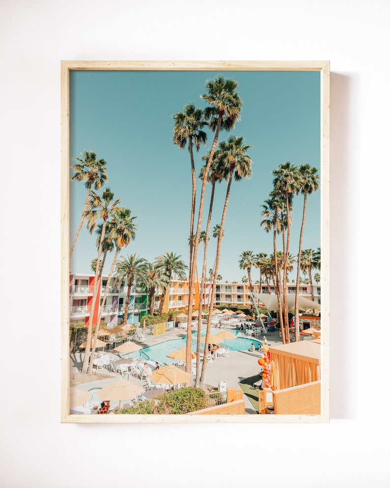 May include: A colorful mid-century modern hotel with a swimming pool surrounded by palm trees and lounge chairs. The hotel has a retro vibe with bright colors and a playful design.