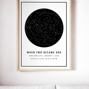May include: A framed print featuring a black and white star map within a black circle. The text "WHEN TWO BECAME ONE" is above the location and date: New York City, January 1, 2018. Coordinates are also listed. The frame is light brown.