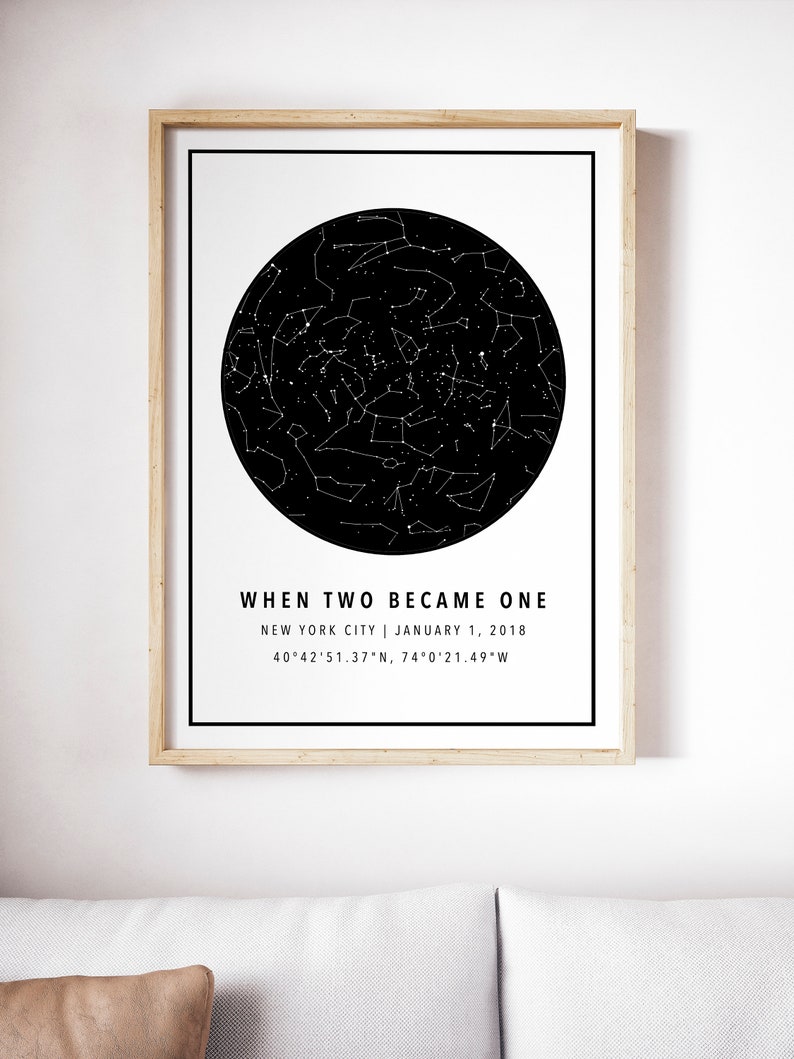 May include: A framed print featuring a black and white star map within a black circle. The text "WHEN TWO BECAME ONE" is above the location and date: New York City, January 1, 2018. Coordinates are also listed. The frame is light brown.