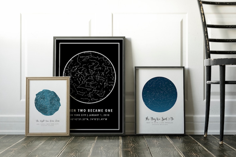 May include: Three framed star charts with black and white designs. One chart is black with a white star map and text. Another is a blue star map with text. The third is a blue star map with text. The frames are black and gold.