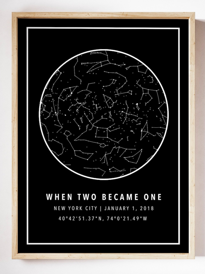 May include: A framed black and white print featuring a star map within a white circle. The text "WHEN TWO BECAME ONE" is below the circle, along with the location and date: New York City, January 1, 2018, and coordinates.